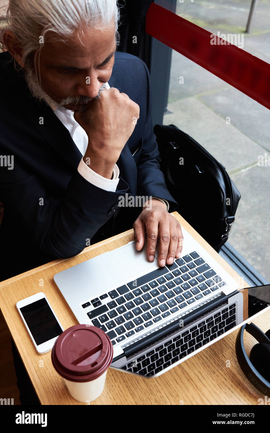 Senior businessman working on laptop in a Coffee shop Banque D'Images