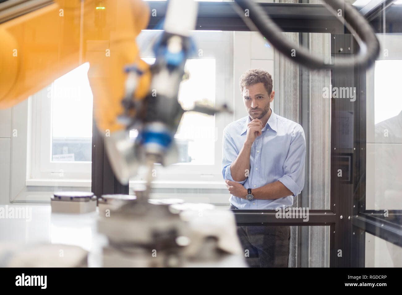 Businessman checking robot industriel dans une entreprise de haute technologie Banque D'Images