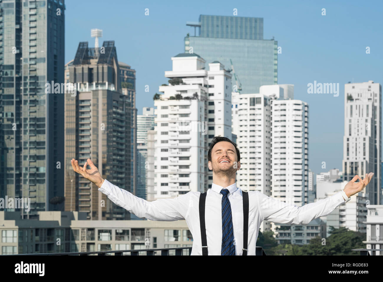 Heureux et content l'homme d'affaires réussi sur les toits de la ville Banque D'Images