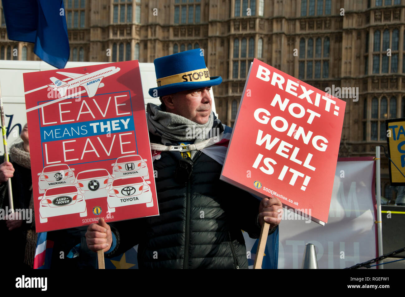 Westminster, Londres. Le 29 janvier 2019. Les manifestants, pour et contre l'extérieur, Brexit Chambres du Parlement que des amendements à l'accord de retrait sont d'un vote. Un Remainer détient un panneau disant 'Brexit : ne va pas bien, c'est elle ?" et l'autre dire "Quitter signifie qu'ils ne quittent' et à un dessin de cinq voitures, Vauxhall, Landrover, BMW, Honda, Toyota. Credit : Jenny Matthews/Alamy Live News Banque D'Images