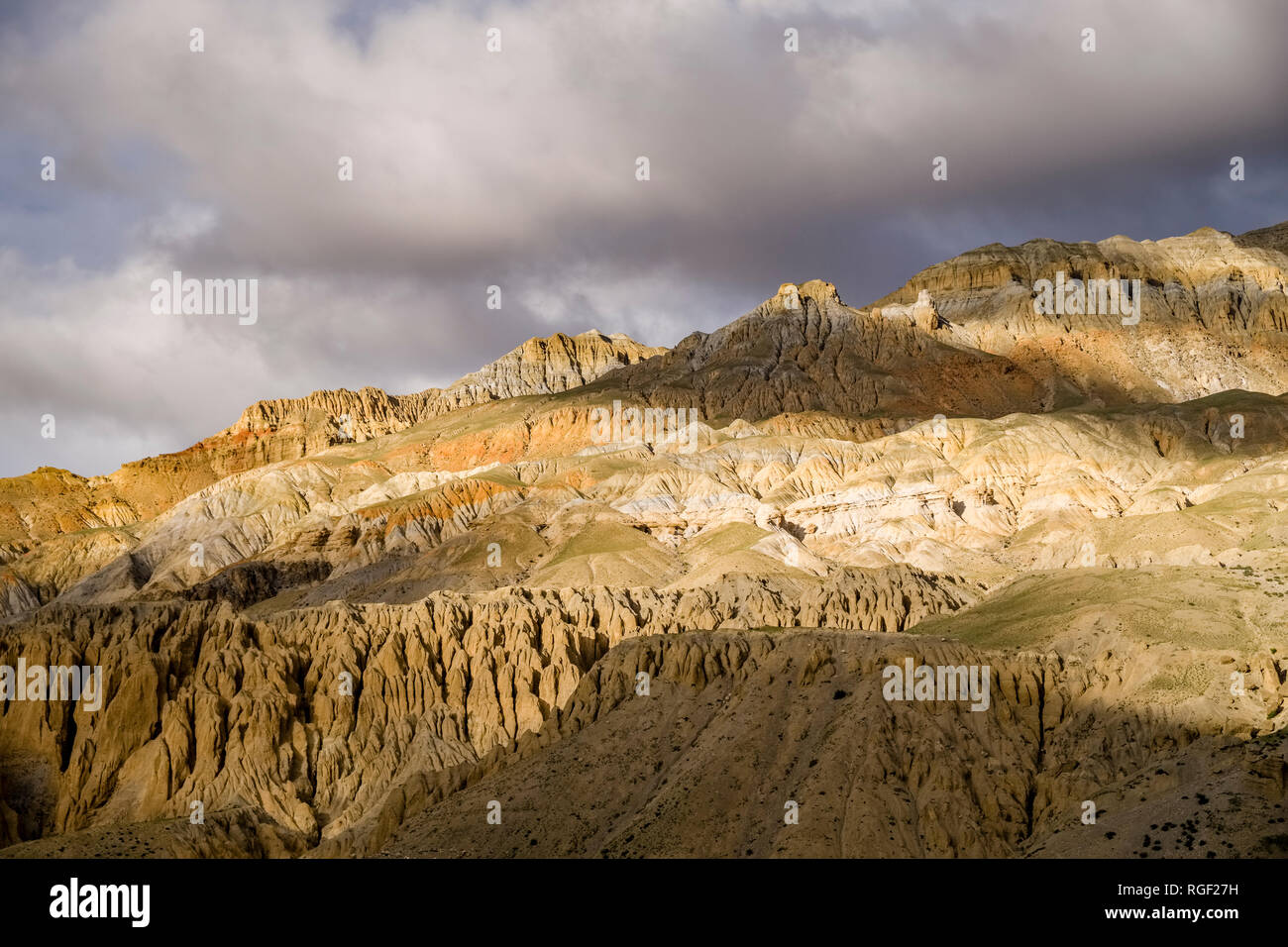 Formations de roches colorées et de collines dans la région de Mustang, sombres nuages de la mousson approchant Banque D'Images