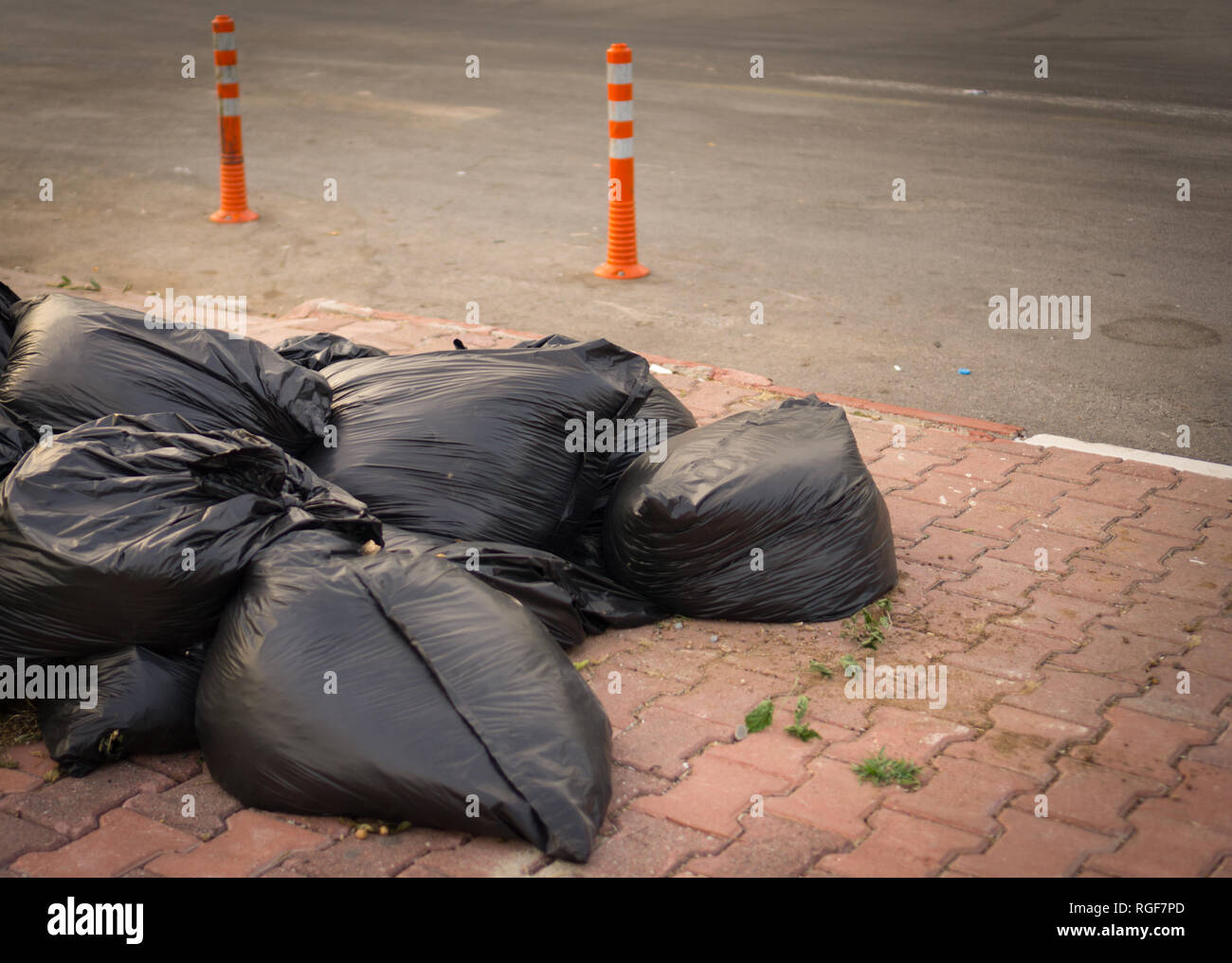 Pile de sacs à déchets noir bas sur la chaussée. Banque D'Images Pile de sacs à déchets noir bas sur la chaussée. Banque D'Images