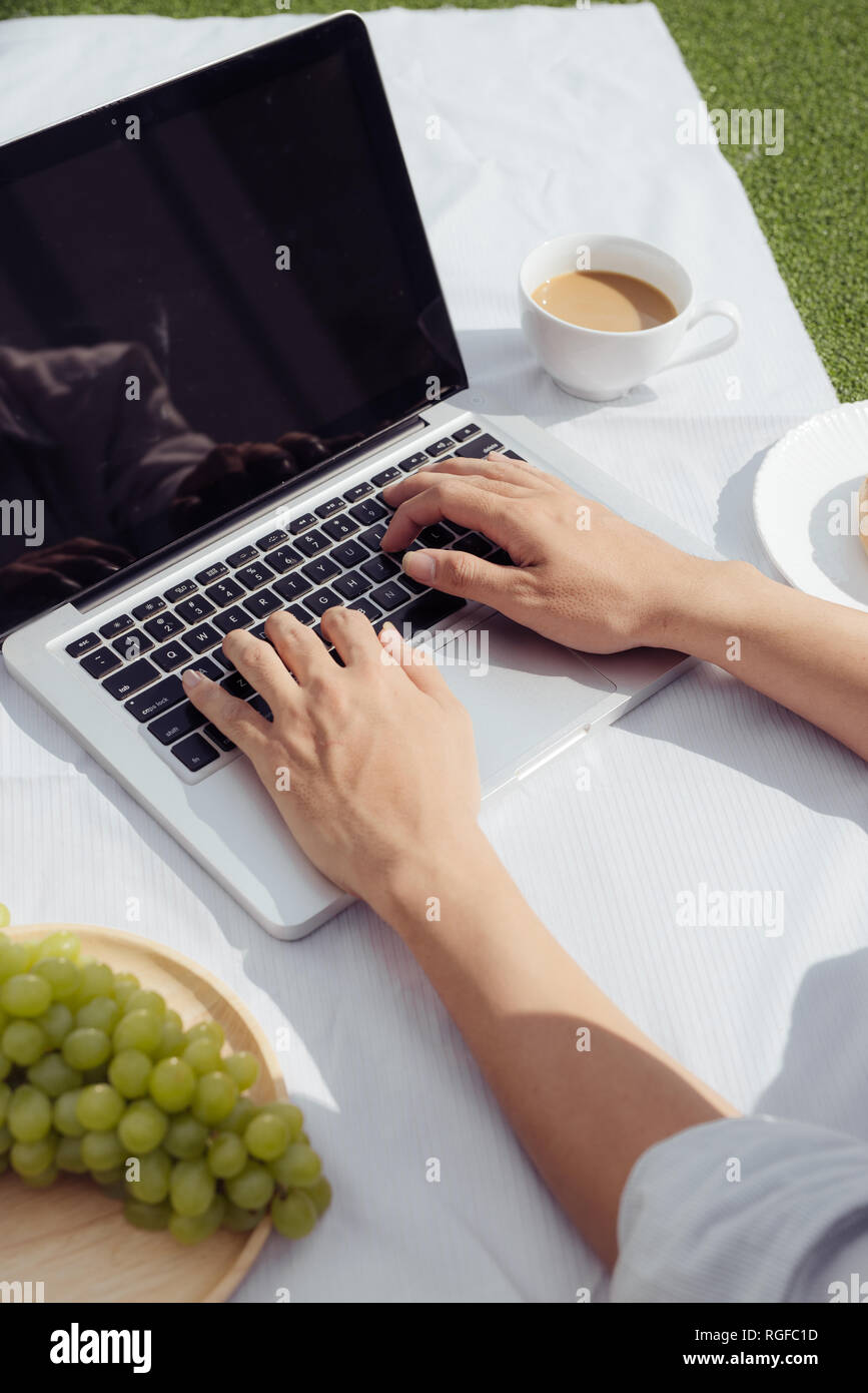 L'homme les mains sur le clavier d'ordinateur portable et le café avec anneau. Un travail facile, style de vie à la maison le matin. Banque D'Images