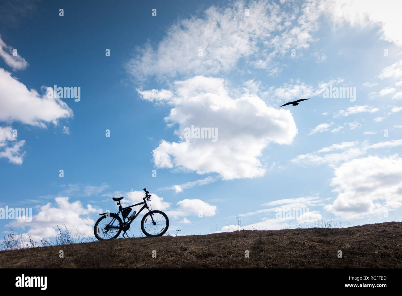 Bike silhouette dans Ciel bleu avec des nuages. symbole d'indépendance et de la liberté avec oiseau en vol Banque D'Images