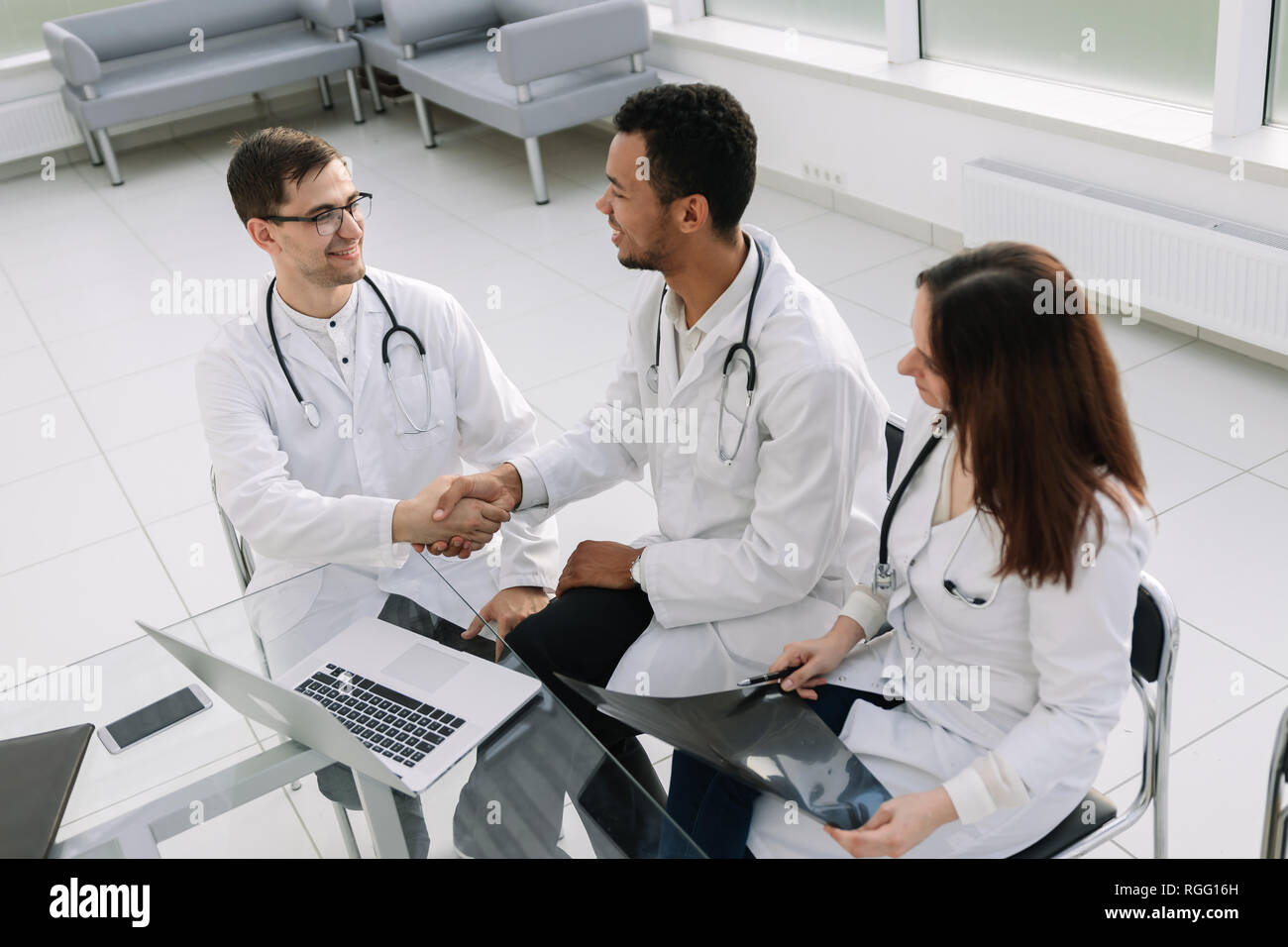 Groupe de médecins discutant l'historique médical du patient lors d'une réunion de travail. Banque D'Images