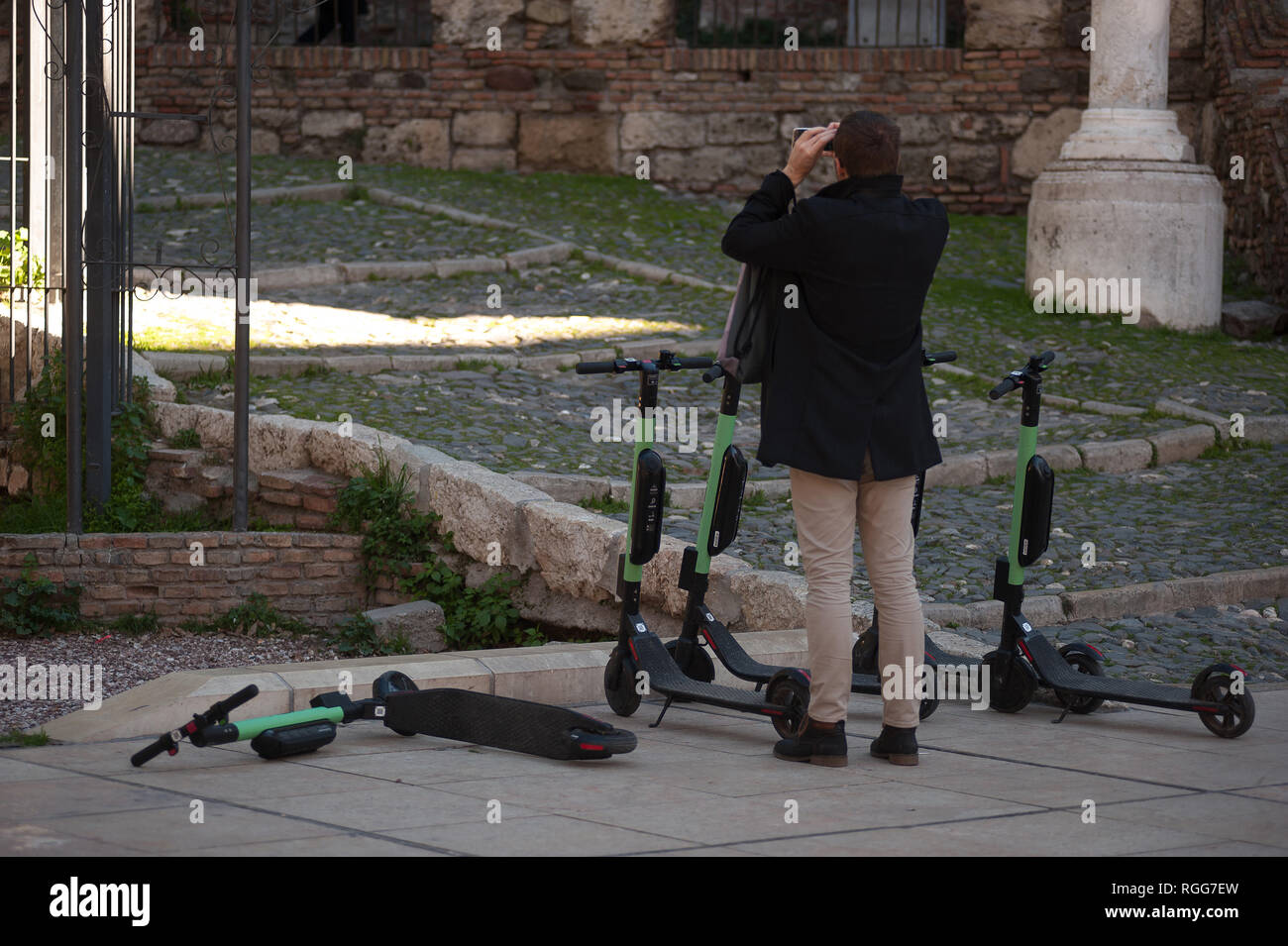 Gratuitement des scooters électriques sont vu garée dans la rue comme un touriste prend des photos d'un monument. Le général espagnol demande Gestion du trafic à partir de maintenant un permis de conduire pour les scooters électriques et une assurance parmi d'autres mesures, selon un nouveau décret du gouvernement espagnol. Au cours des derniers mois a été passé plus d'accidents à l'aide de scooters électriques et un décès l'année dernière. Le gouvernement pense comme ceci pour réglementer l'utilisation de ce transport et améliorer la sécurité. Banque D'Images