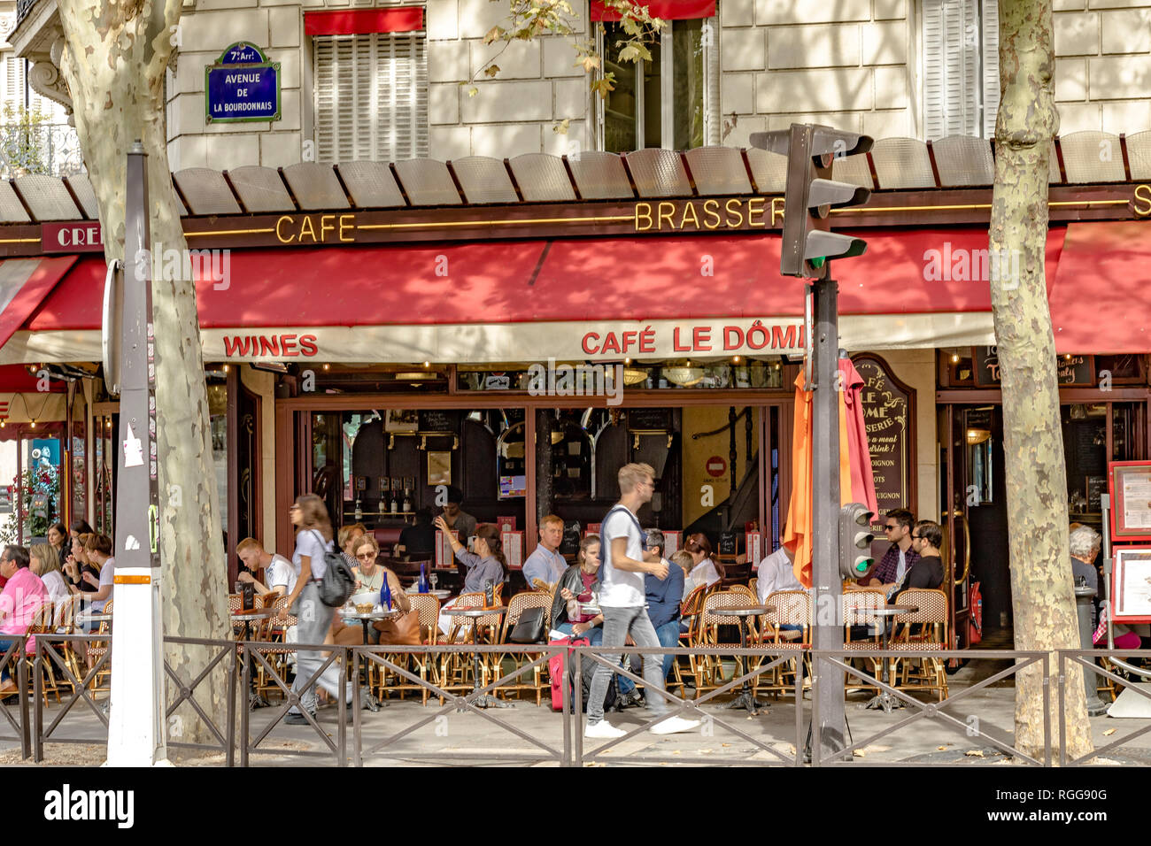 Personnes dînant à l'extérieur sur le trottoir du café le Dôme, rue Saint-Dominique, lors d'une journée d'été à Paris, France Banque D'Images