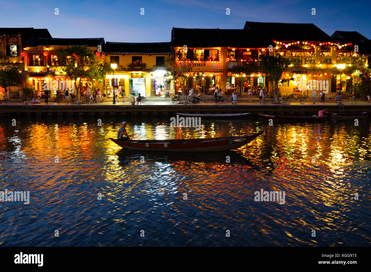 Bateau naviguant par allumé maisons qui se reflètent sur la rivière Thu Bon à Hoi An, Vietnam Banque D'Images