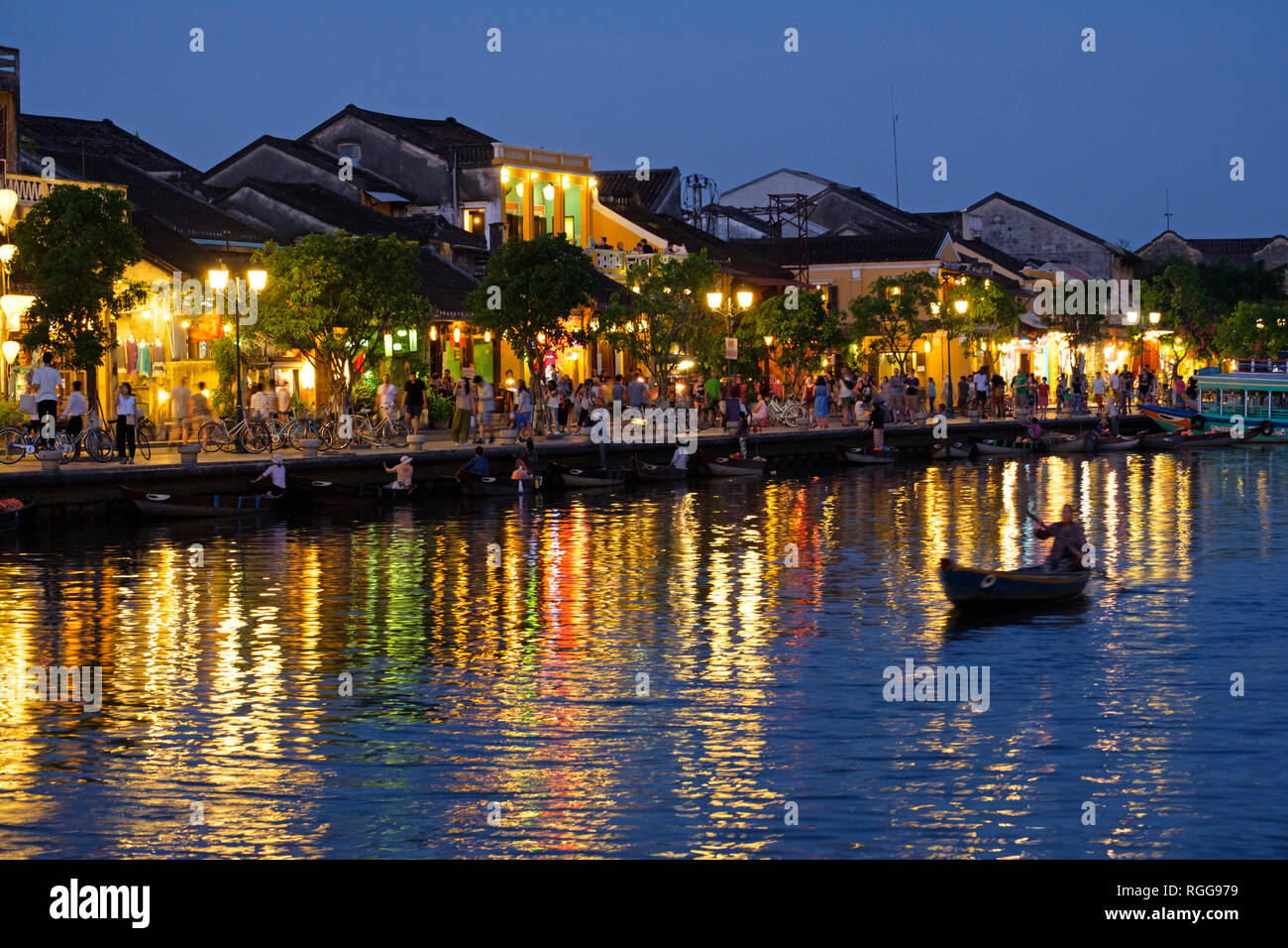 Bateau naviguant par allumé maisons qui se reflètent sur la rivière Thu Bon à Hoi An, Vietnam Banque D'Images