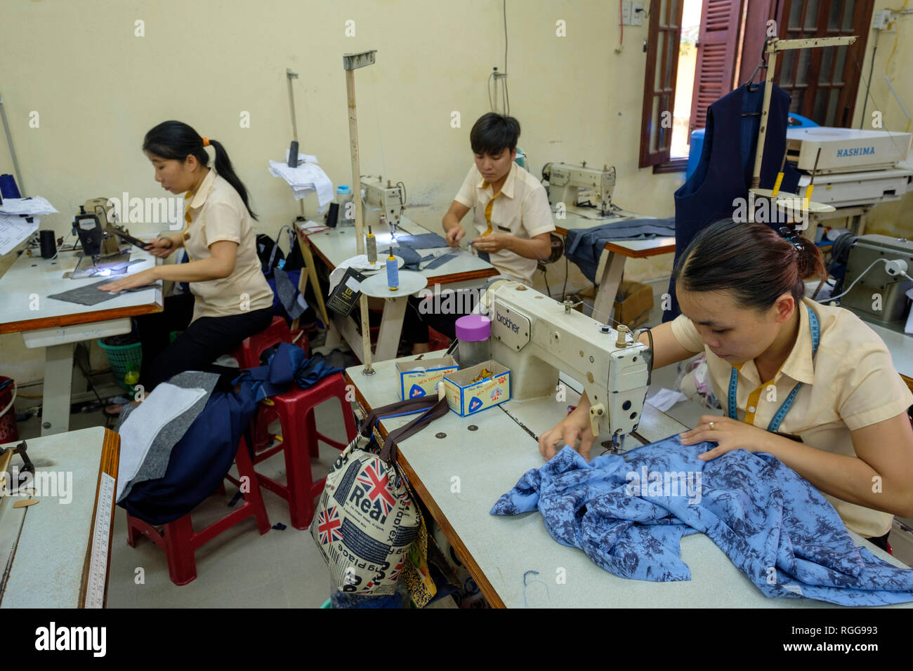 Machines à coudre avec des femmes travaillant dans une usine de vêtements au Vietnam, Asie Banque D'Images
