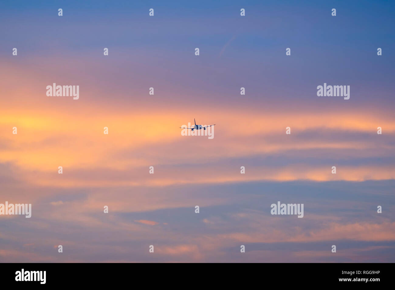Silhouette d'un avion volant dans le coucher du soleil Banque D'Images