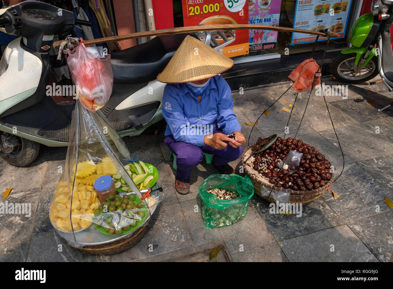 Femme portant non traditionnelles vietnamiennes la chapeau conique de la préparation de l'alimentation de rue à vendre au Vietnam, en Asie du sud-est Banque D'Images