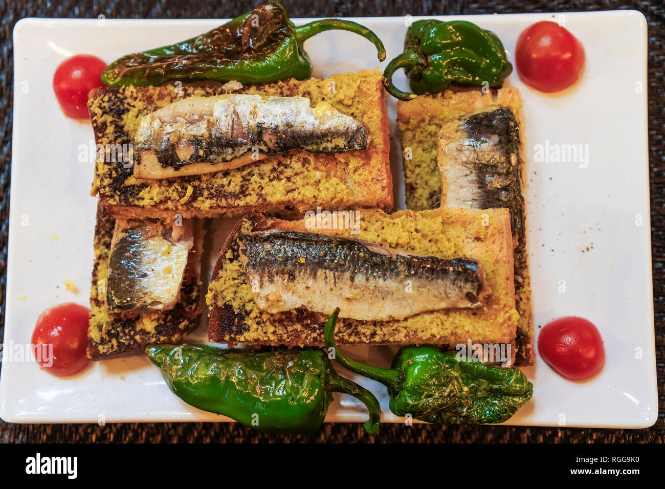 Portugal Lisbonne sardines traditionnel servi la nourriture.Libre Vue de dessus des sardines grillées sur du pain grillé avec de l'huile d'olive poivrons tomates et garnir Banque D'Images