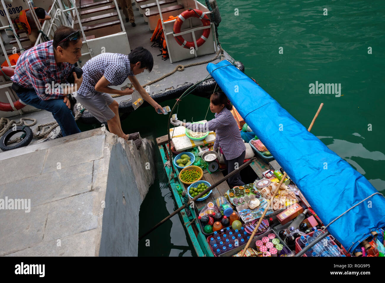 Les clients de l'achat de produits à partir d'un bateau sur la baie d'Halong, Vietnam, Asie Banque D'Images