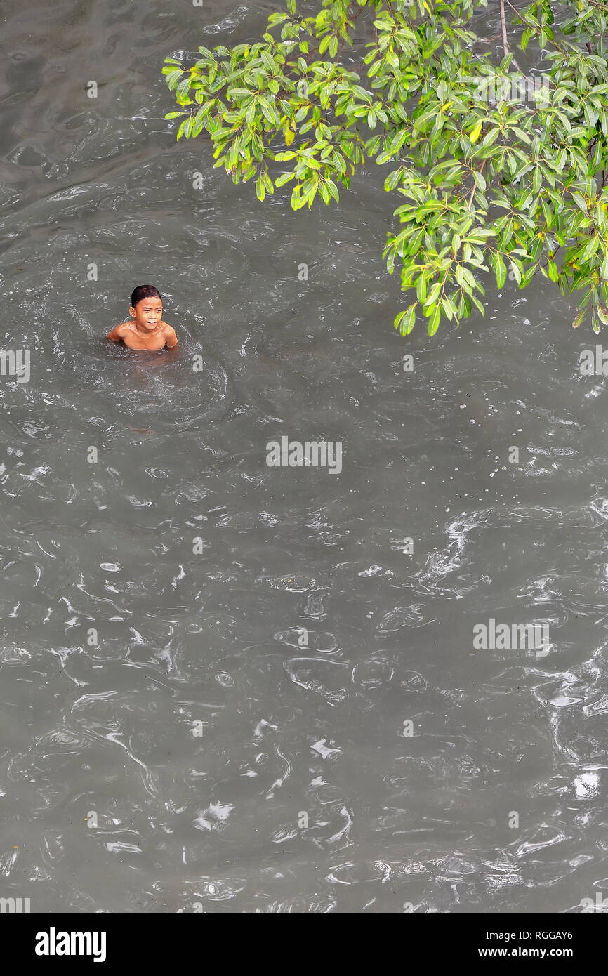 Manille, Philippines-October 24, 2016 Philippines : garçon prend un bain dans l'eau grise de la rivière Pasig comme il est sous le Willian A.Jones Memorial B Banque D'Images