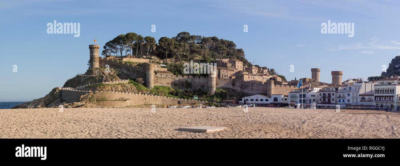 Forteresse de Tossa de Mar avec la plage et la nouvelle ville : la muraille en pierre massive et les tours de ce lieu de la plage de sable le long de la côte catalane. Les bateaux sont tirés sur la plage ci-dessous et de la nouvelle ville le long de la plage. Banque D'Images