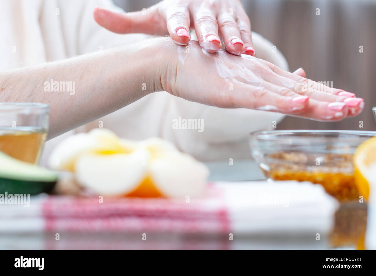 La femme l'application de la crème sur ses mains hydratant et nourrissant avec les cosmétiques naturels close-up. Concept d'hygiène et de soins pour la peau Banque D'Images