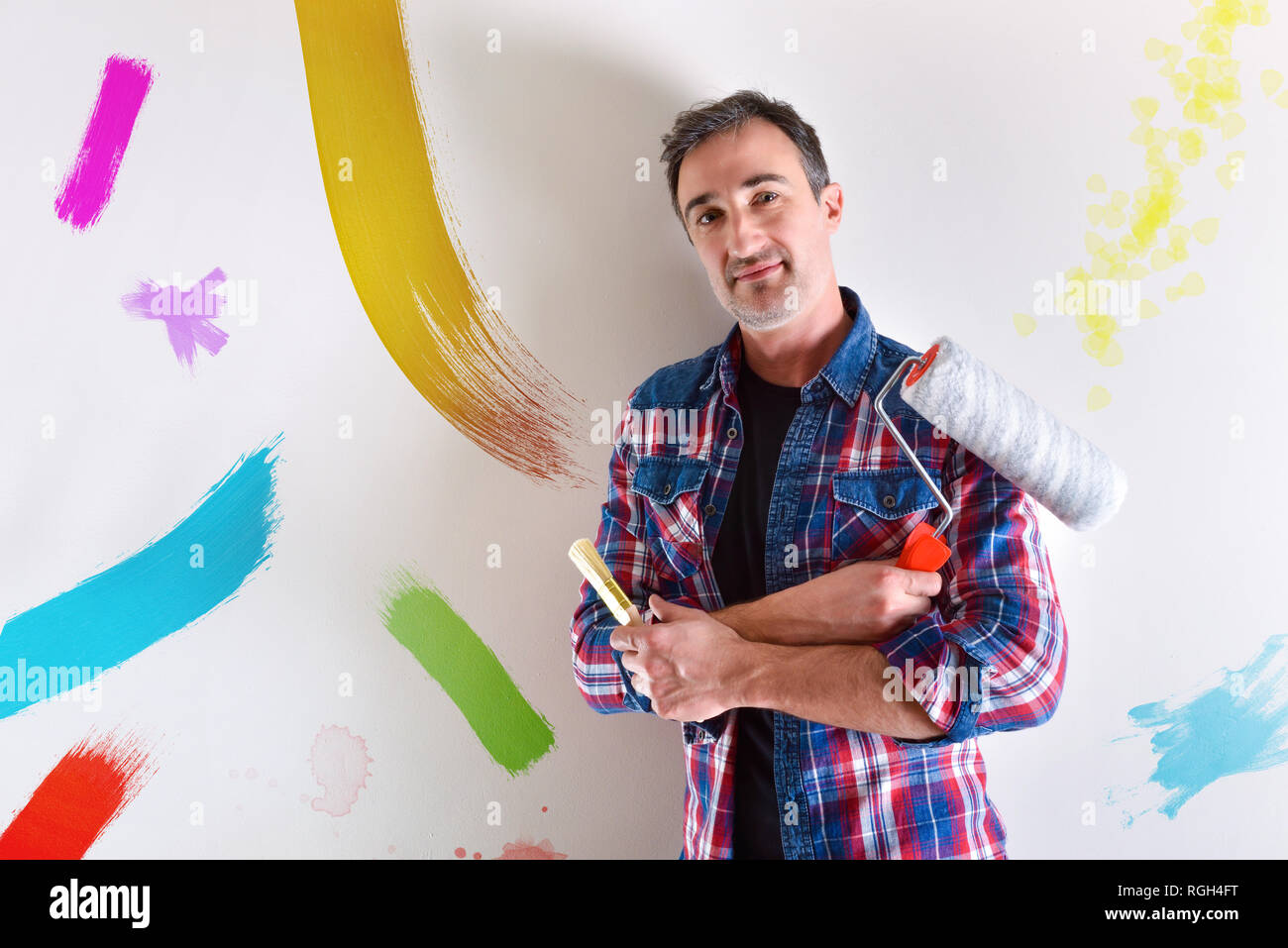 Homme avec les armes et les outils dans les mains avec des échantillons de couleur sur le mur. Vue de face. Composition horizontale. Banque D'Images