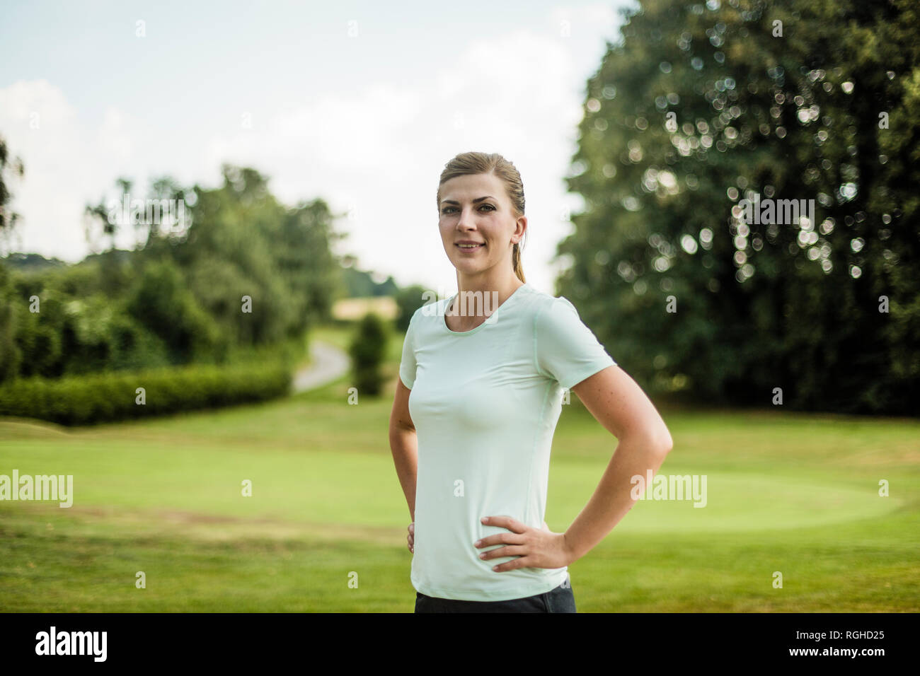 Portrait of smiling sportive young woman standing in a park Banque D'Images Portrait of smiling sportive young woman standing in a park Banque D'Images
