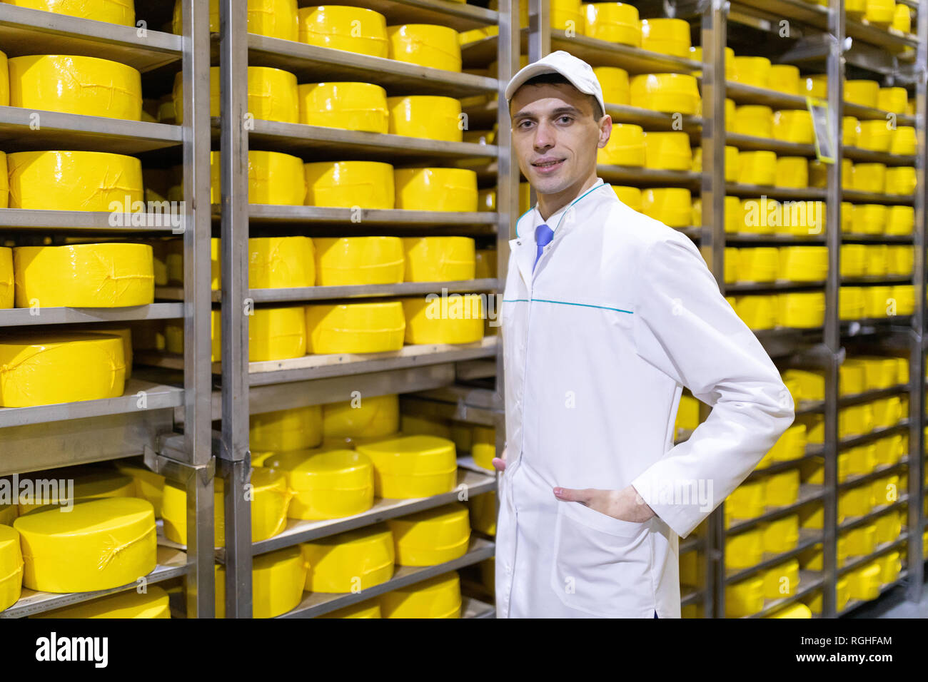 Dans un manteau blanc est dans l'entrepôt de fromage dans la boutique pour  la production de beurre et de fromage. Le processus de production à l'usine  de Photo Stock - Alamy