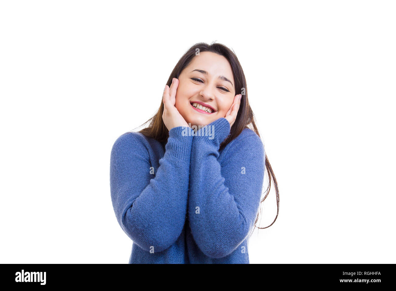 Jeune femme joyeuse posing holding hands on cheeks smiling to camera isolated over white background. Banque D'Images