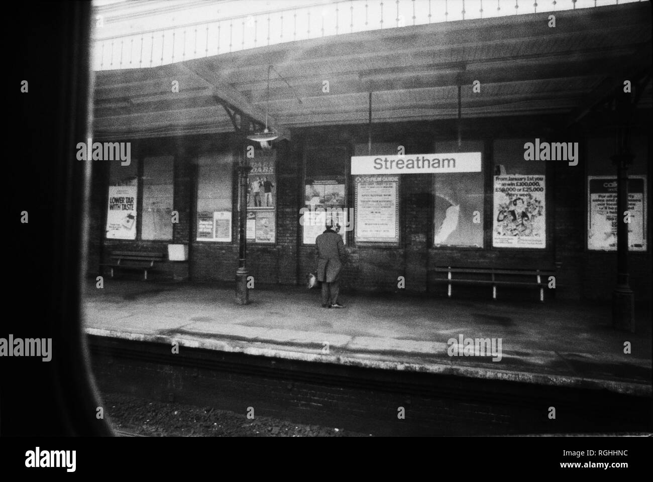 Image d'archive d'un homme seul debout sur Streatham British Rail Station, Londres, Angleterre, 1979, l'air à travers la fenêtre d'un train porte-slam Banque D'Images