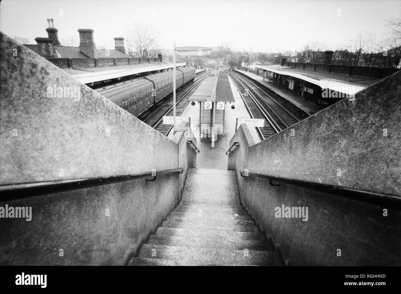Archive image monochrome de la plate-forme d'une gare ferroviaire du sud de Londres avec train à porte en slam en attente à la plate-forme, 1979, Londres, Angleterre Banque D'Images