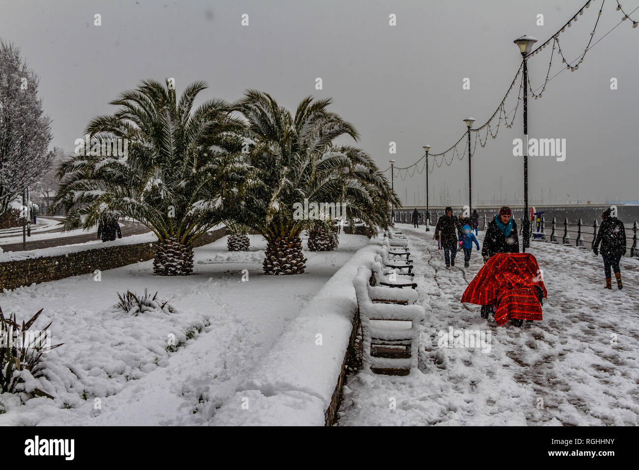 Une famille aux prises avec la neige et la glace en marchant le long du front de mer de Torquay lors de la "bête de l'Est' tempête en mars 2018. Banque D'Images