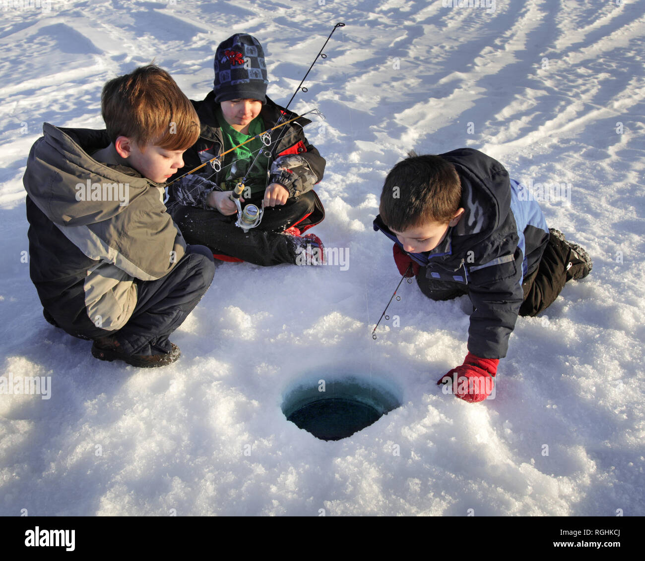 3 garçon à la pêche sur glace en Alaska, les frères s'amusant Banque D'Images