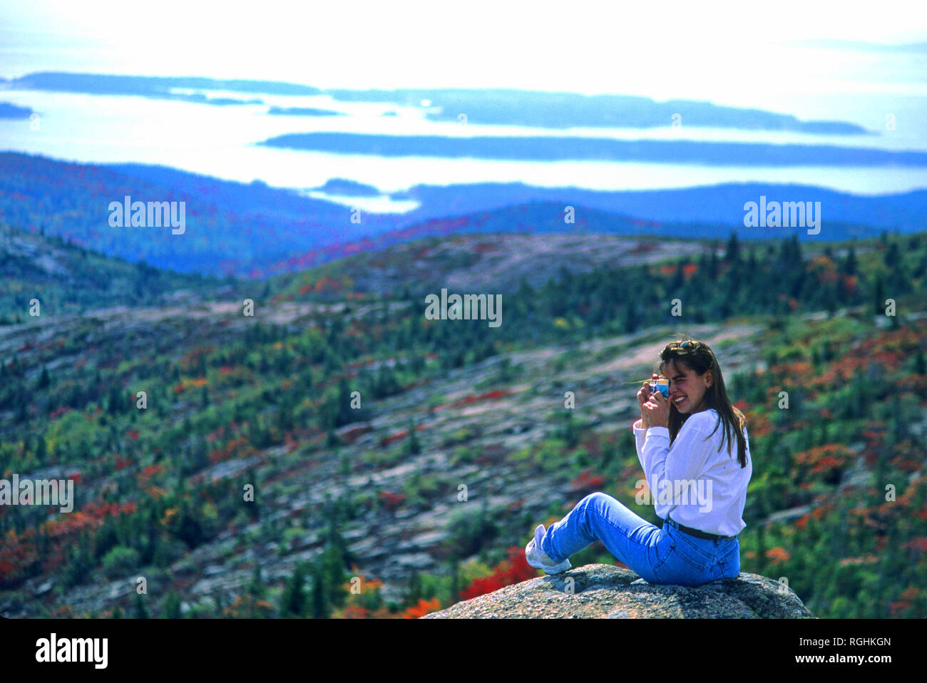 Une jeune femme prend une photo dans l'Acadia National Park, Maine. Sur le haut de Cadilac Mountain. Banque D'Images