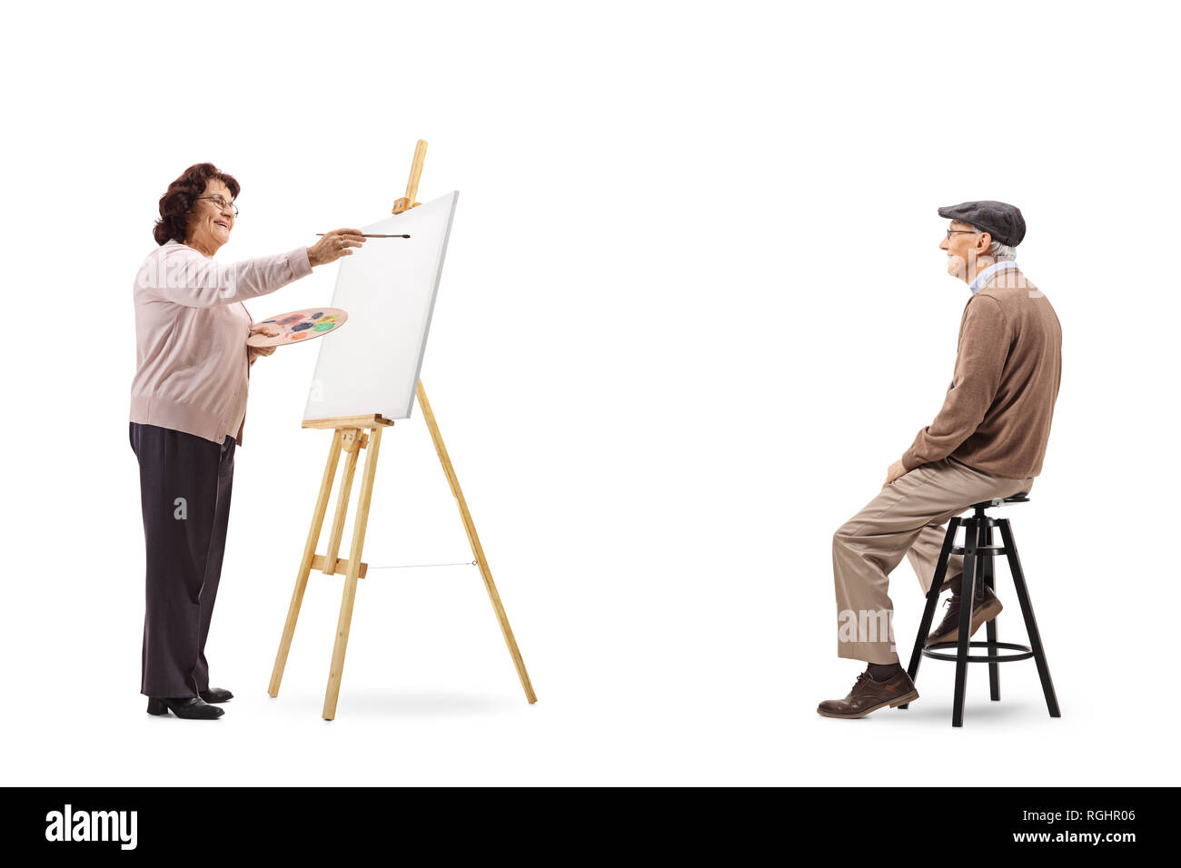 Tourné sur toute la longueur d'une femme âgée dessinant un portrait of senior man sur une toile isolé sur fond blanc Banque D'Images