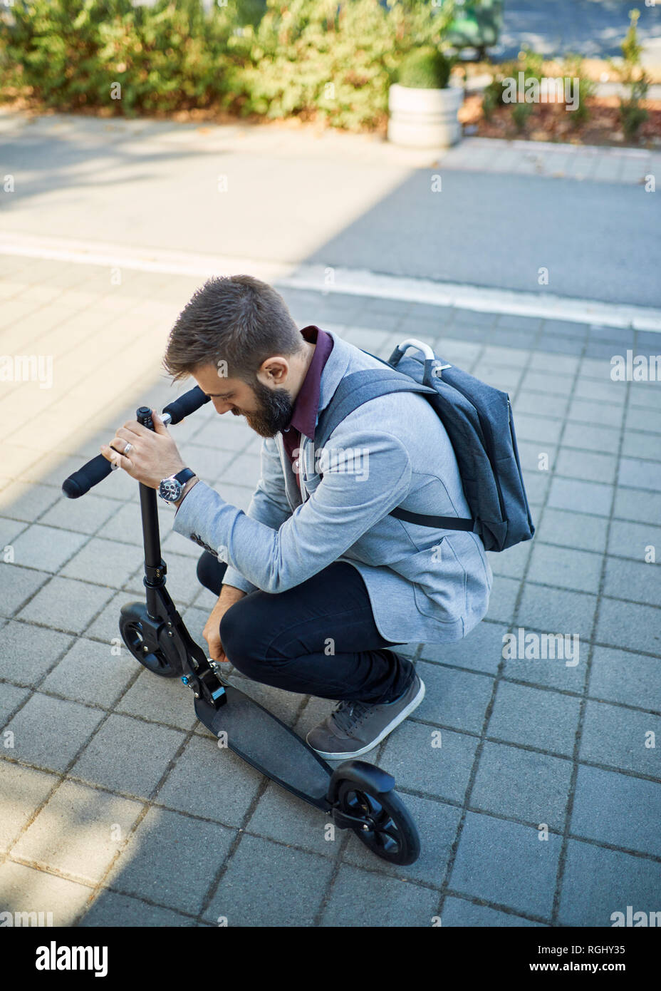 Businessman adjusting scooter Banque D'Images