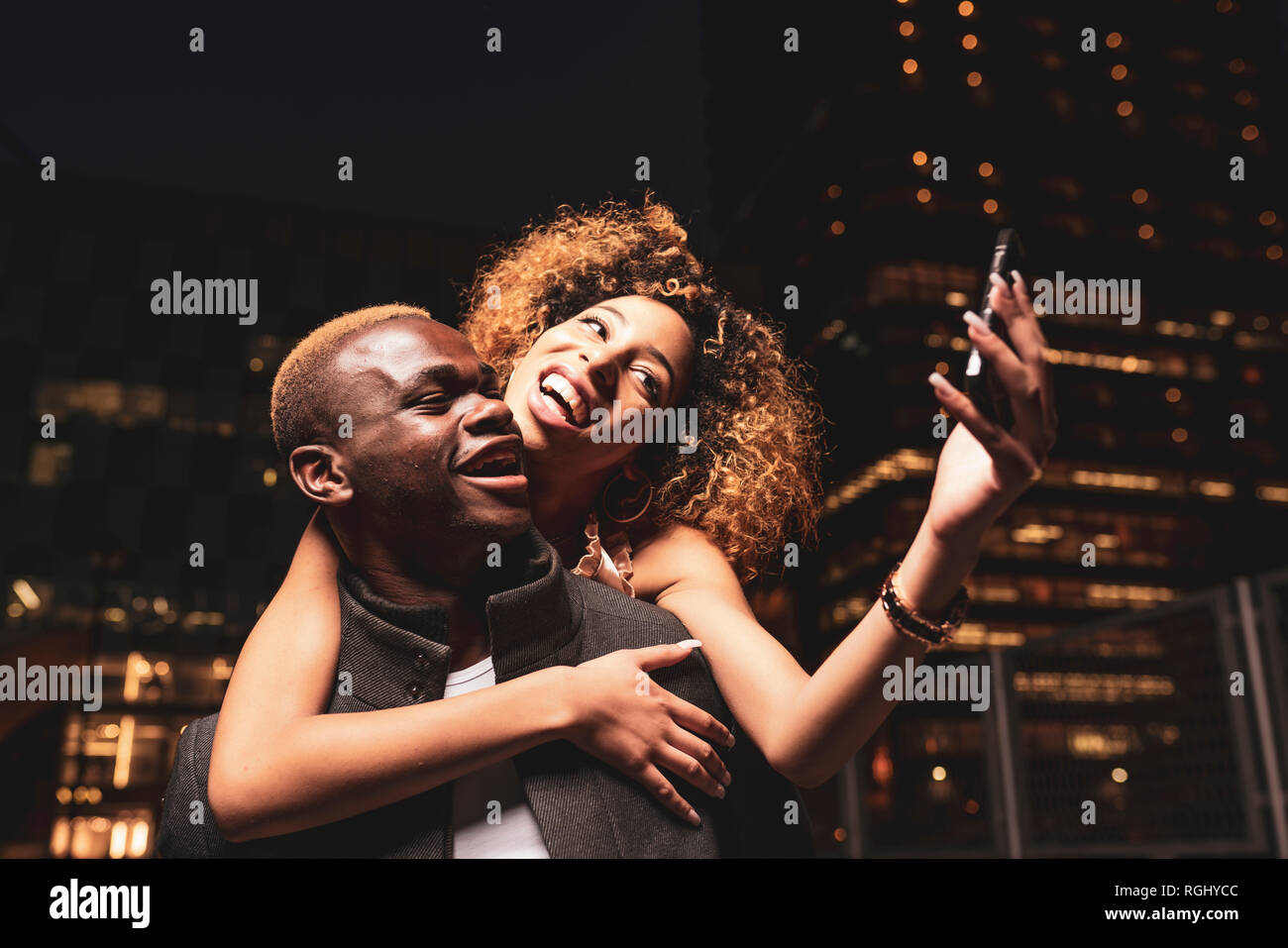 Happy young couple at night selfies dans la ville Banque D'Images