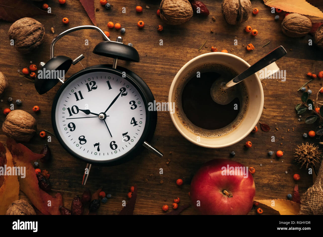 Automne coffee time, vue du dessus télévision laïcs de vintage réveil avec tasse de café chaud sur une table décorée avec des fruits d'automne et de feuilles d'érable sec Banque D'Images