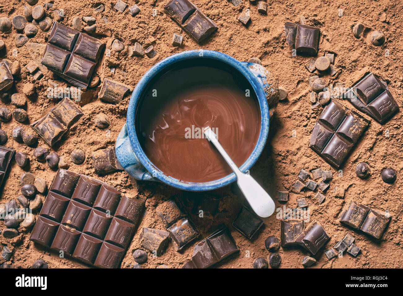 Le chocolat fondu dans un bol entouré de morceaux de chocolat et de poudre de cacao Banque D'Images