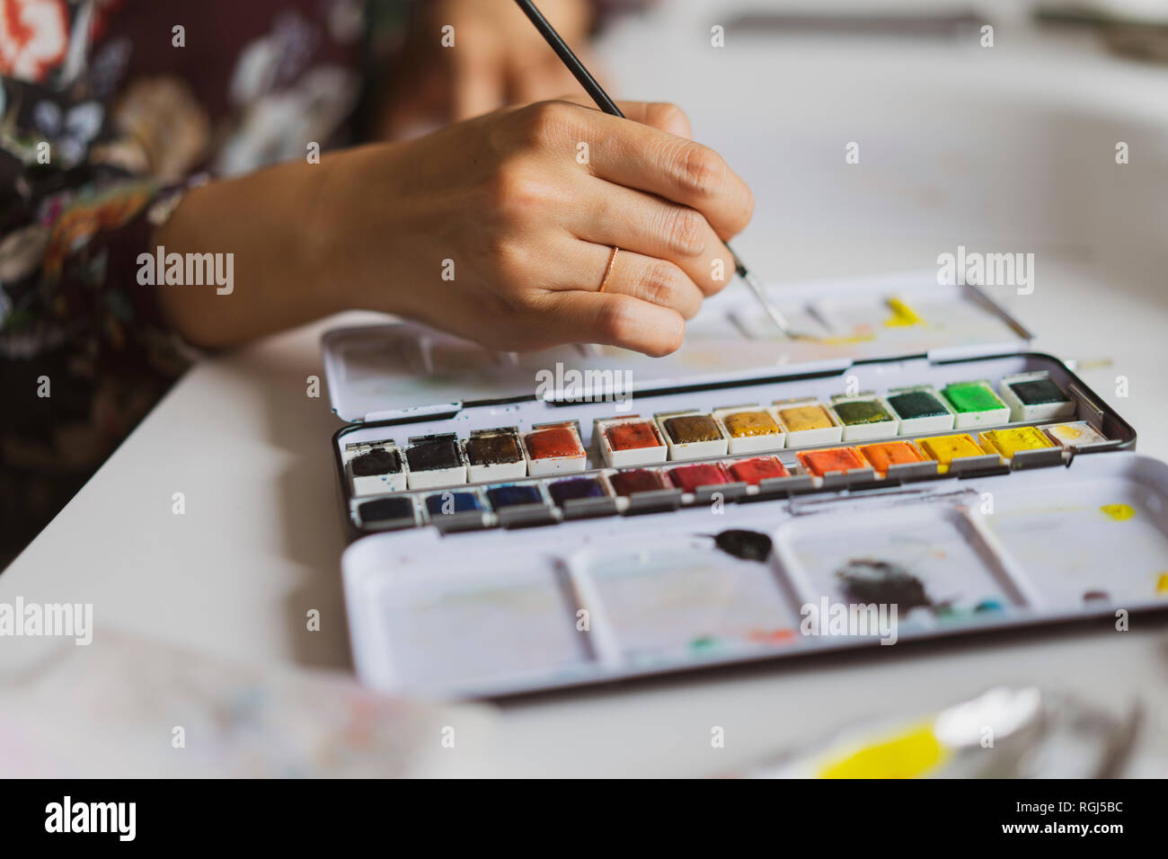 Illustrator en peinture à un bureau dans un atelier, close-up Banque D'Images