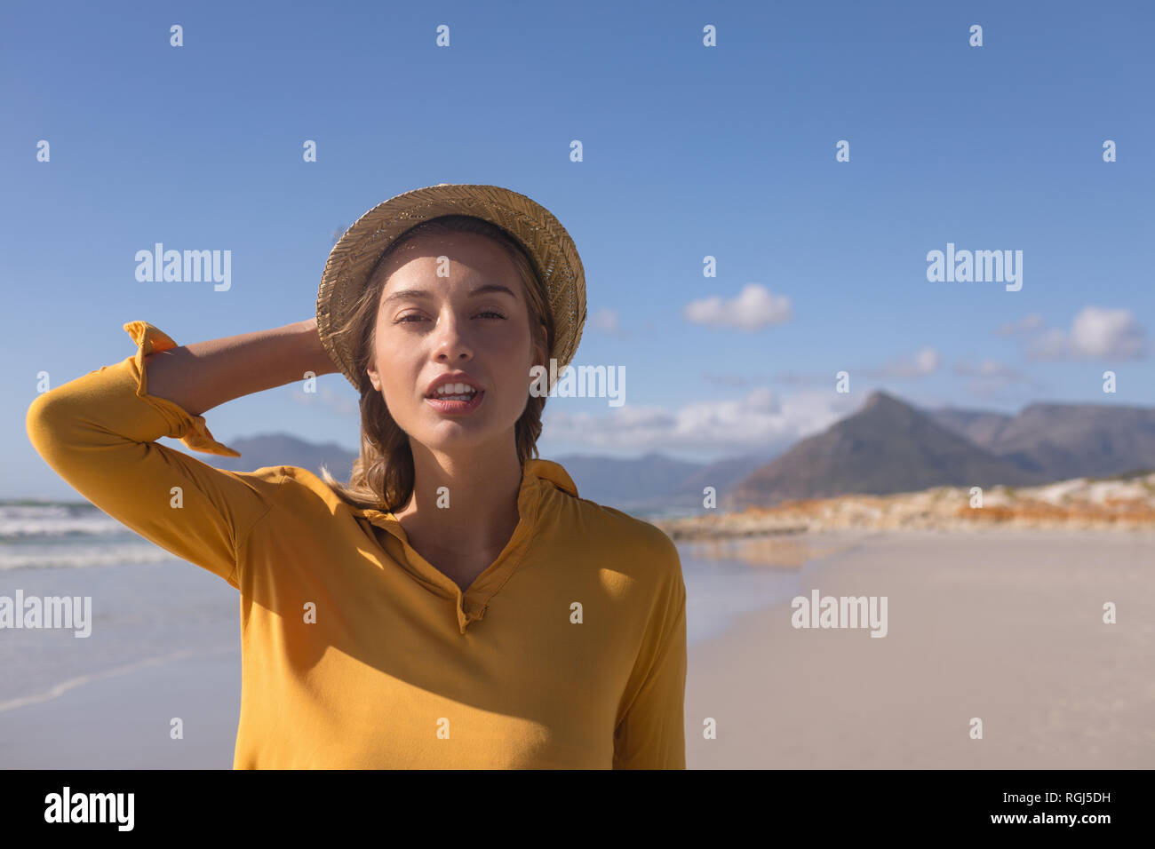 Woman wearing hat standing on the beach Banque D'Images