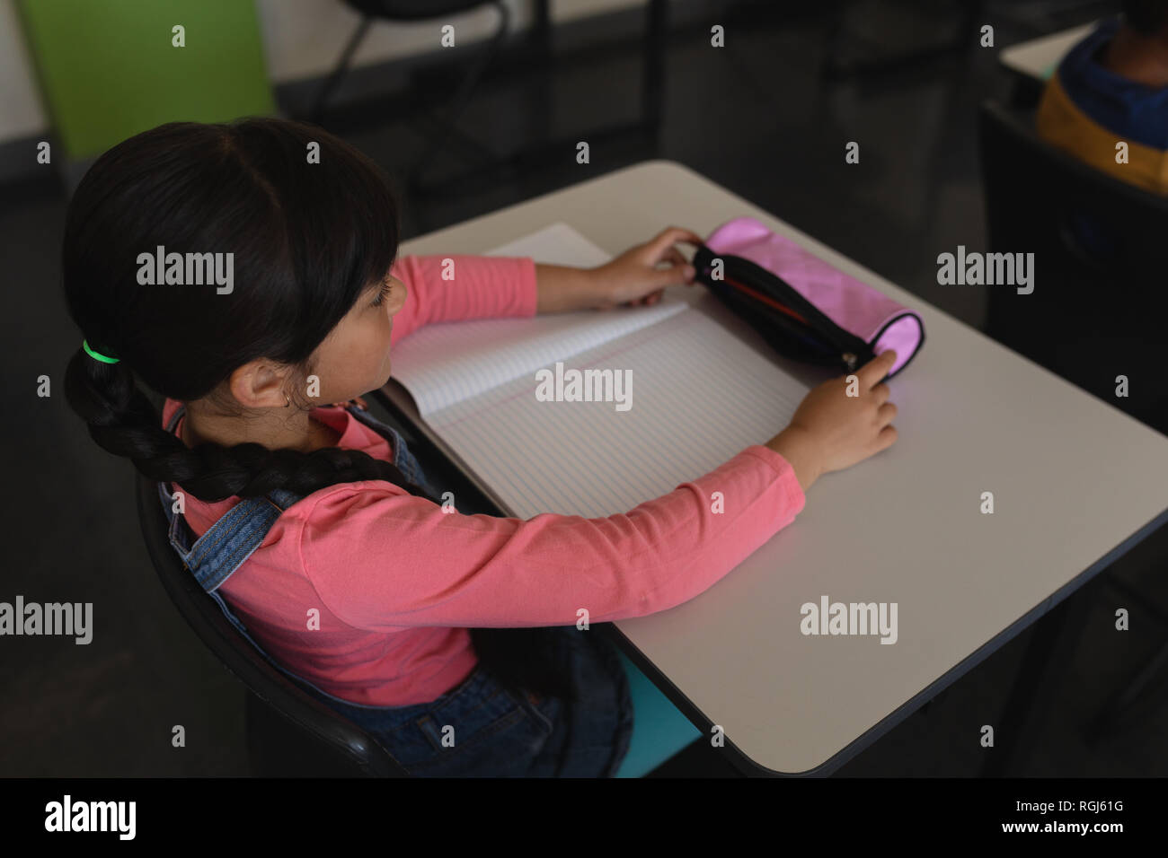 Lycéenne qui étudient en classe, assis à un bureau à l'école Banque D'Images