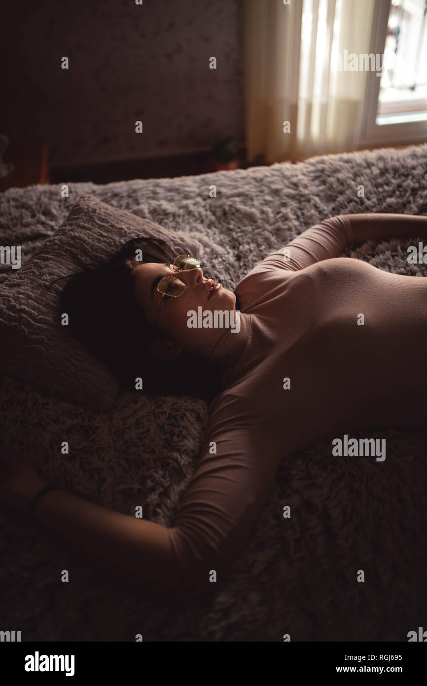 Jeune femme couché sur le lit Banque D'Images