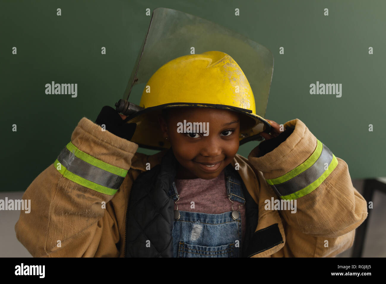 Vue avant d'écolière noir avec le feu à l'aspect uniforme en classe de l'appareil photo Banque D'Images