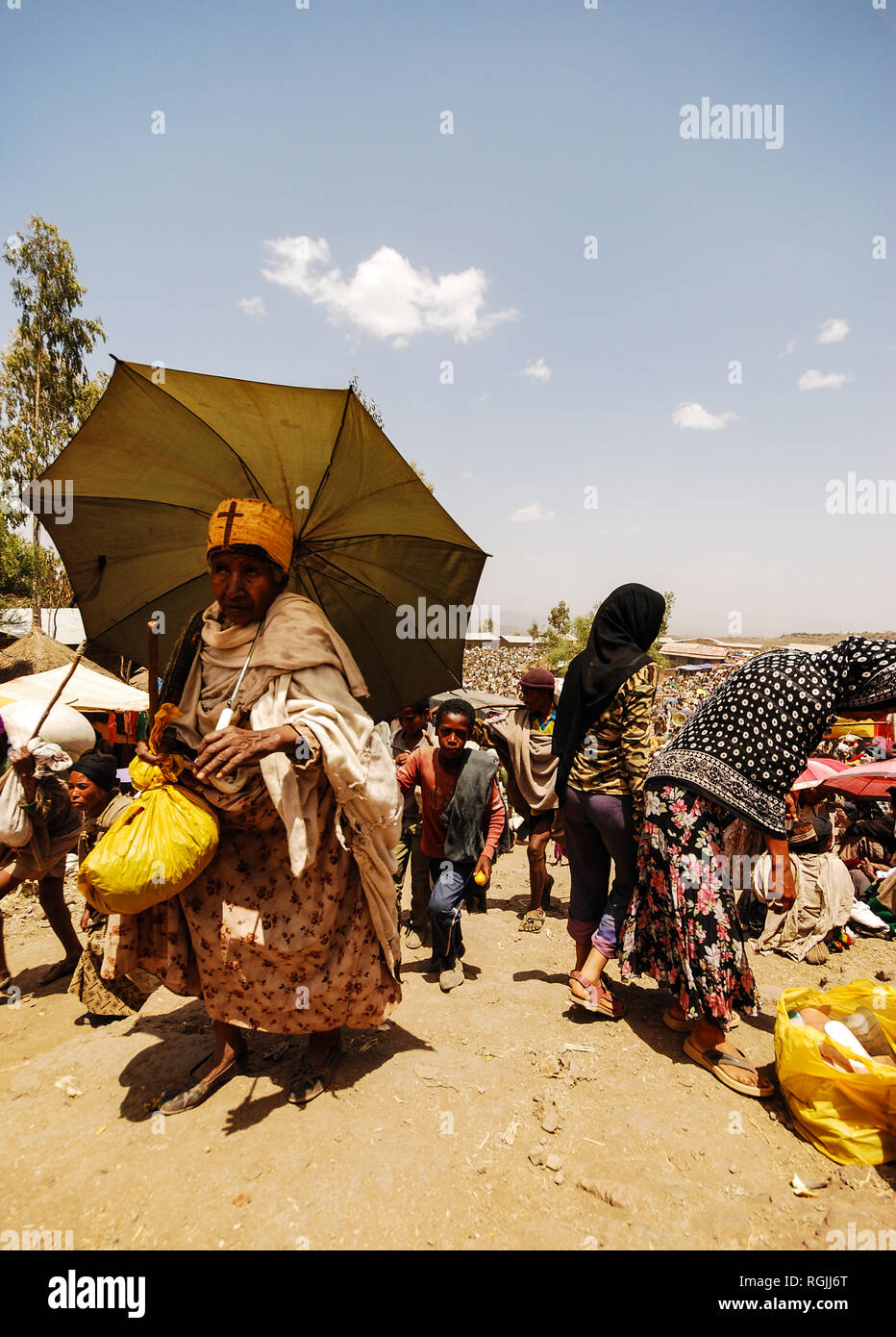 Lalibela, Ethiopie, du 13 juin 2009 : femme de retour de la marché avec un sac et un parapluie pour se protéger du soleil Banque D'Images