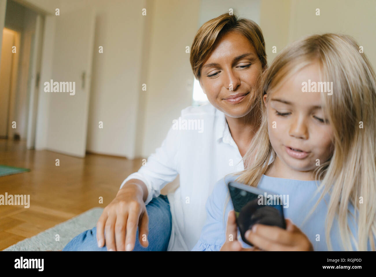 Mère et fille ensemble looking at smartphone Banque D'Images