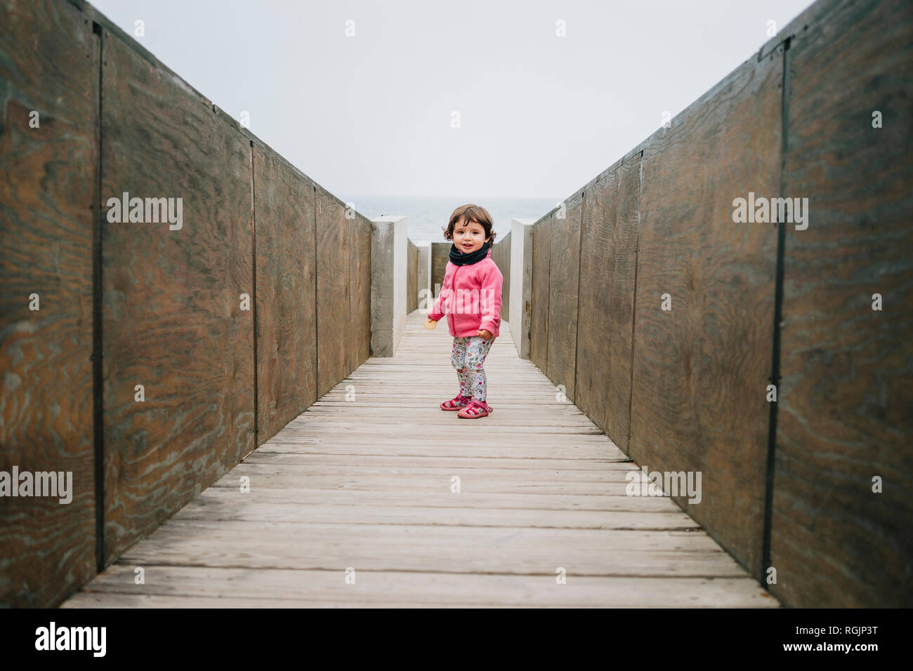 Baby Girl marche sur une passerelle en bois Banque D'Images