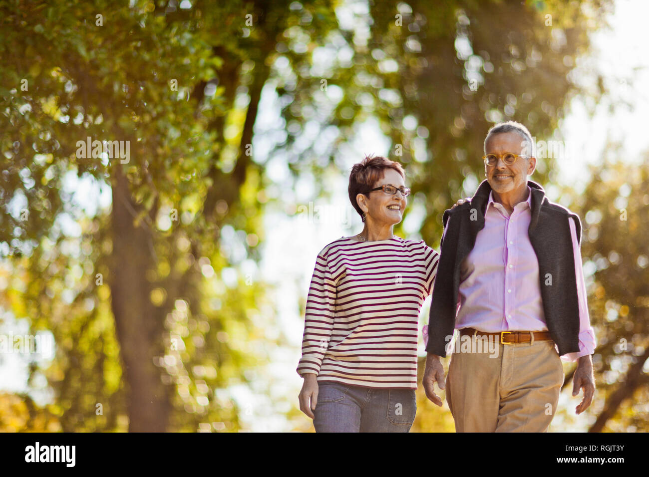 Smiling couple en train de marcher dans un parc ensemble. Banque D'Images