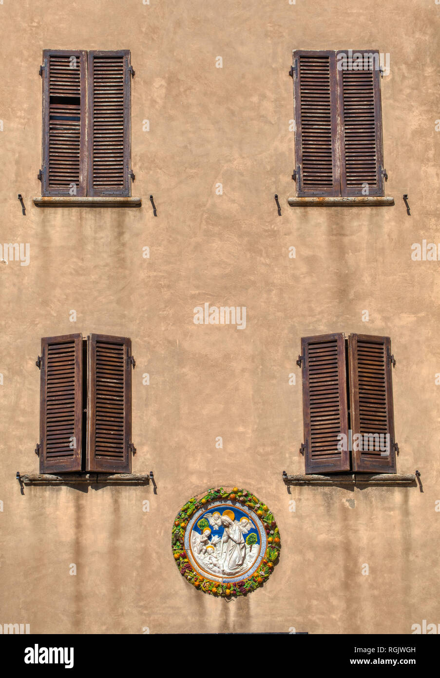 Photographie de quatre fenêtres Brown contre un mur de plâtre patiné brun, gravé à la main avec des pierres colorées des anges. Coeur de la Toscane Florence Banque D'Images
