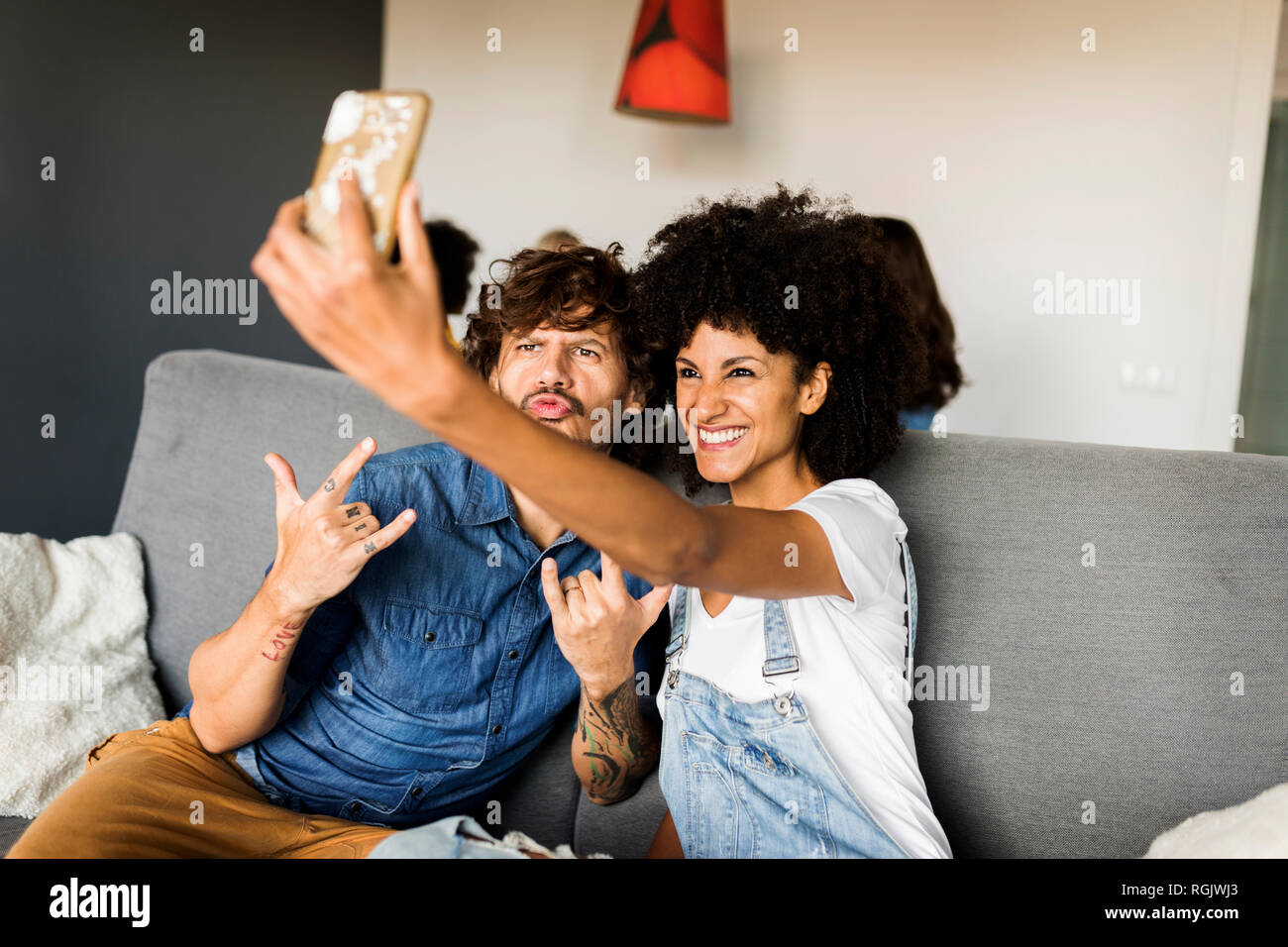 Heureux couple sitting on couch selfies prendre une Banque D'Images