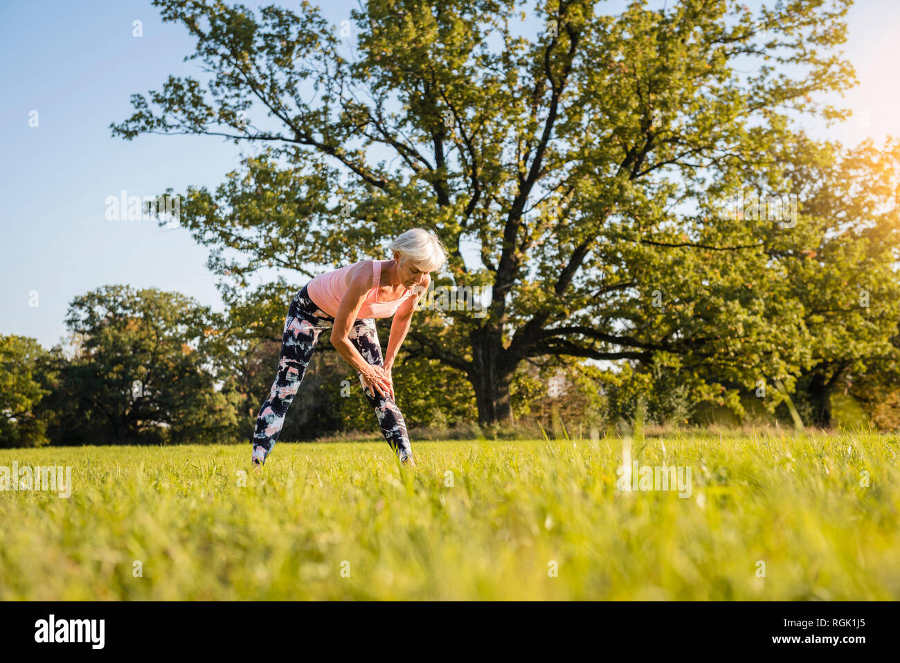 Senior woman stretching on meadow rural Banque D'Images