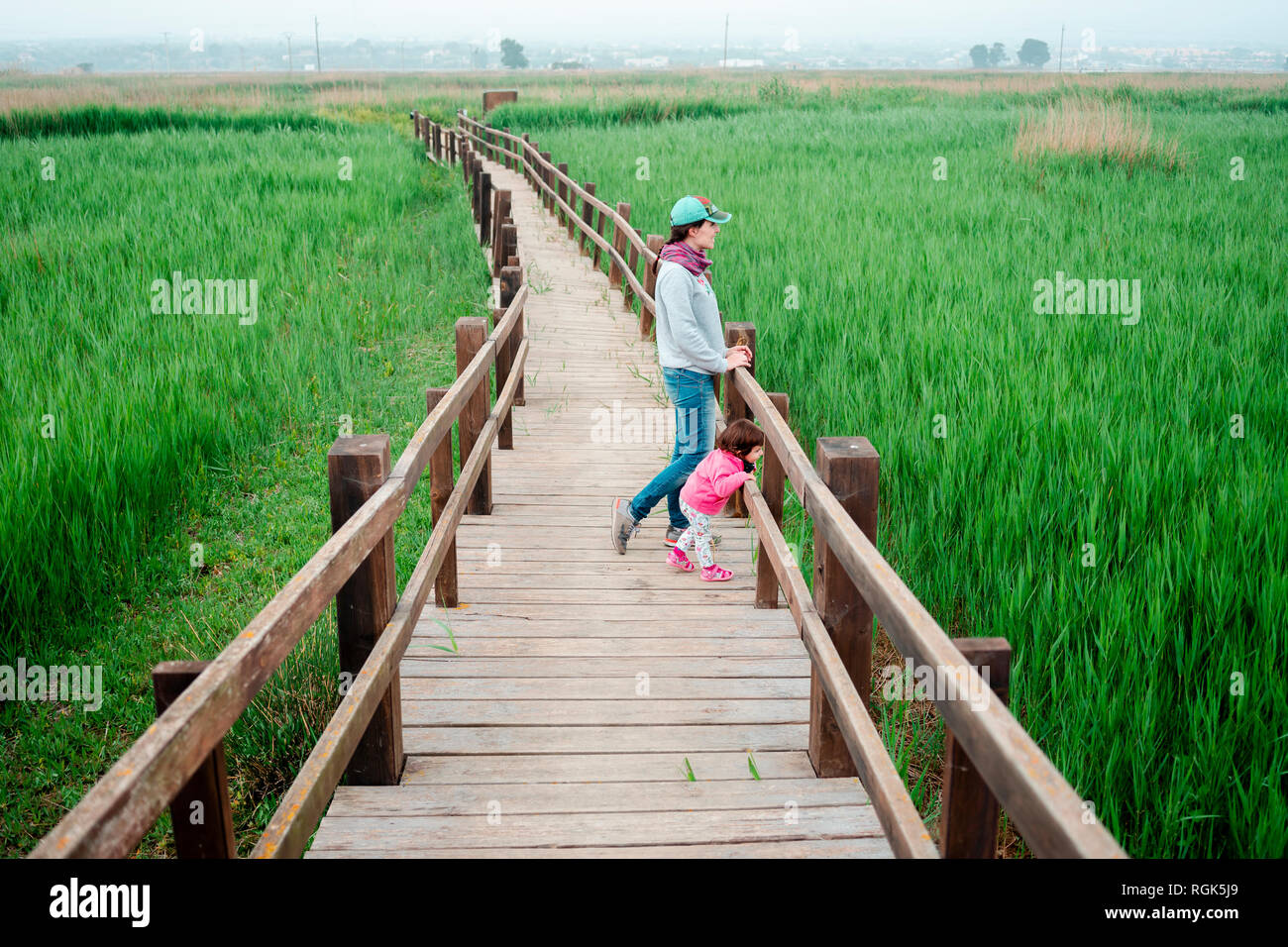 Mère et fille sur une passerelle en bois, à la recherche de champs de riz Banque D'Images