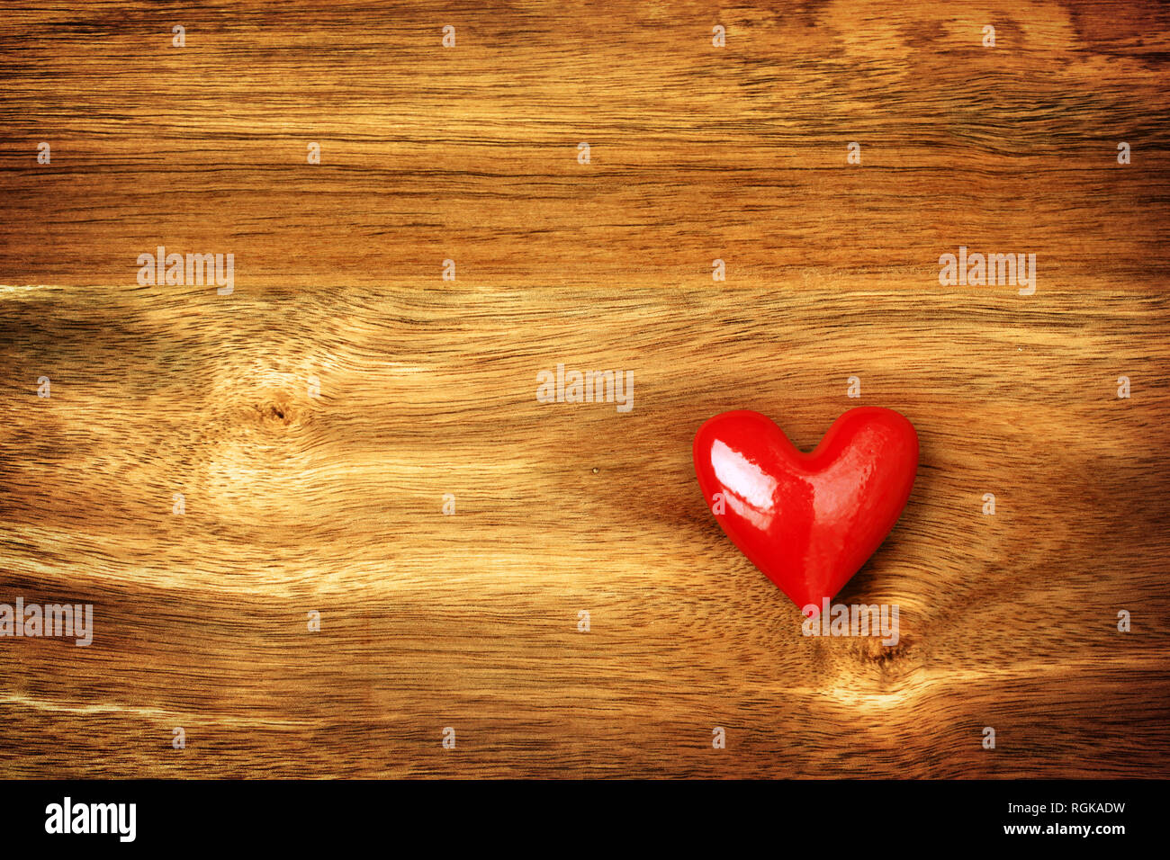 Coeur rouge brillant sur fond de bois Banque D'Images