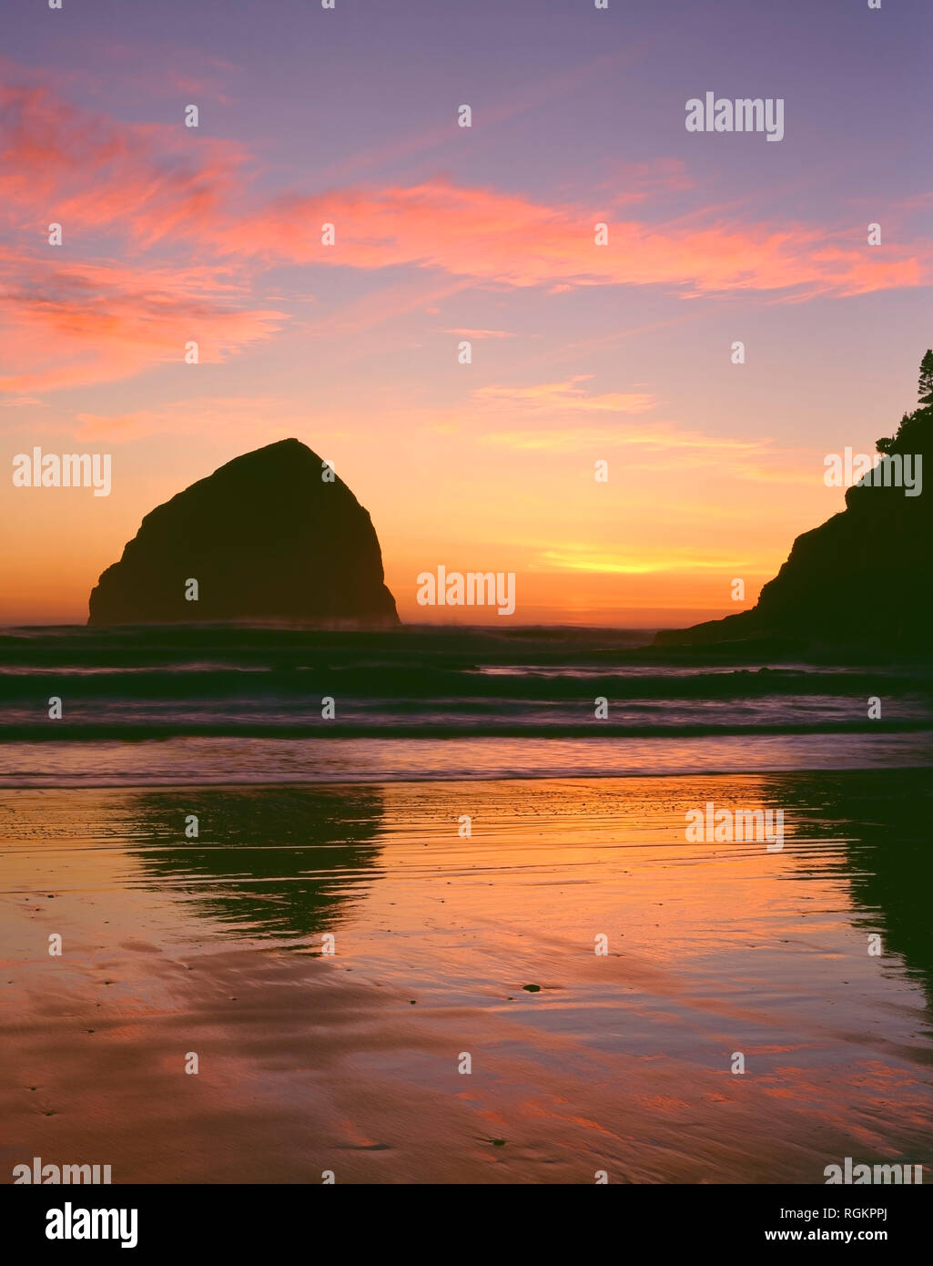 USA, New York, Cape Kiwanda State Park, Haystack Rock et Cape Kiwanda se profilent par le coucher du soleil. Banque D'Images
